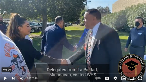Principal Peter Lambert shakes hands with a woman and they